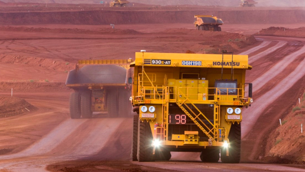 Large haul trucks operating along a road at an open pit oil sands mine