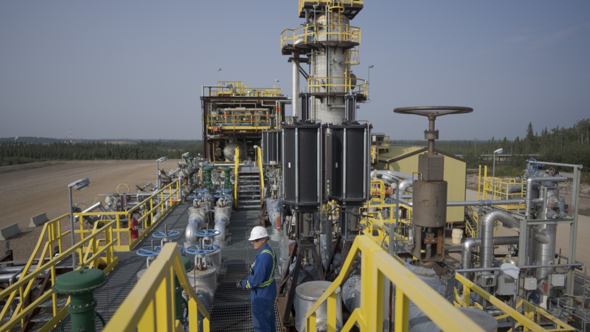 Oil sands processing facility with operators monitoring production equipment
